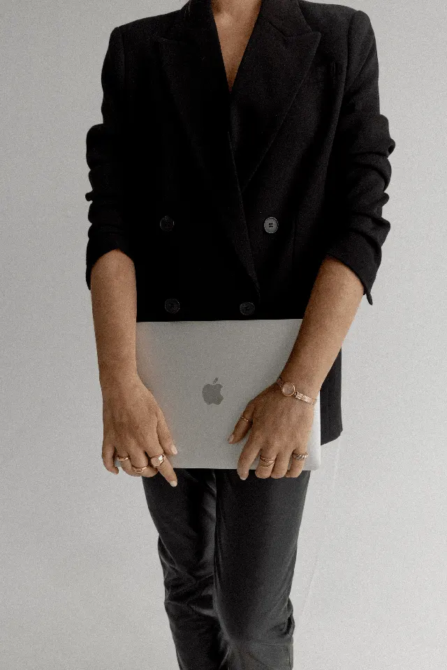 Detalhe de um look preto com notebook