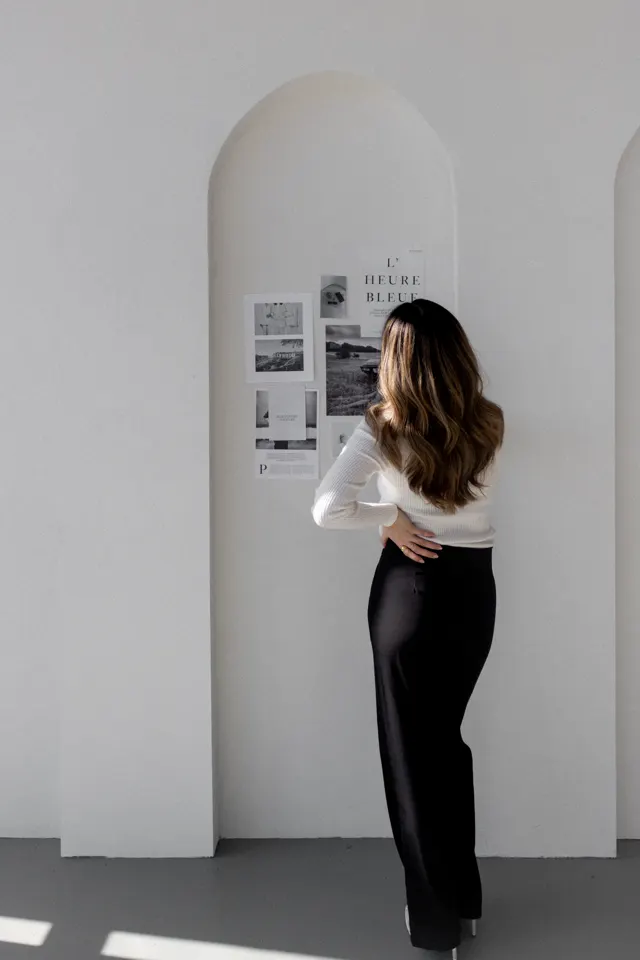 Mulher diante de um espelho com referências de design