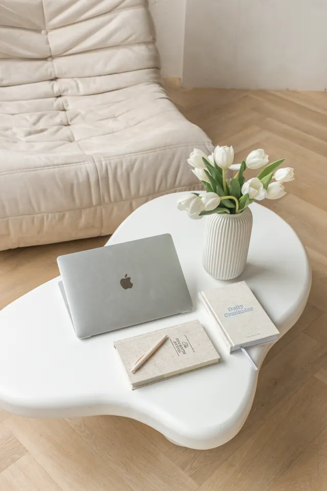 Mesa com notebook, caderno e flores