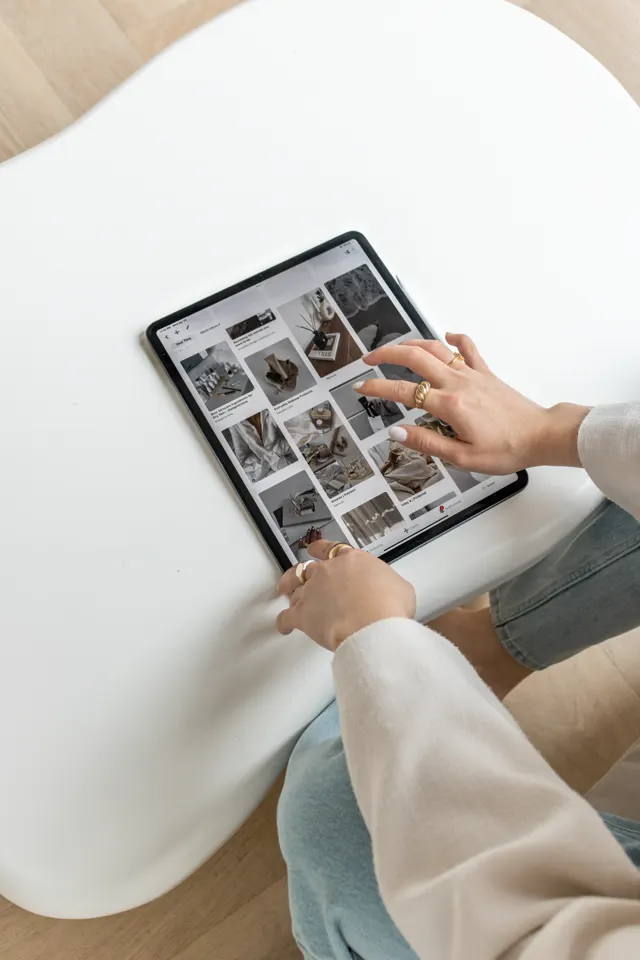 Mãos navegando em referências visuais no tablet