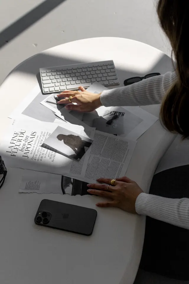 Mãos folheando referências de design sobre a mesa