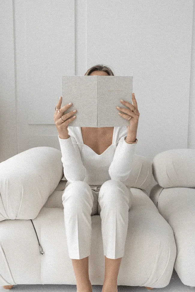 Foto faceless de uma mulher com o rosto coberto por um caderno